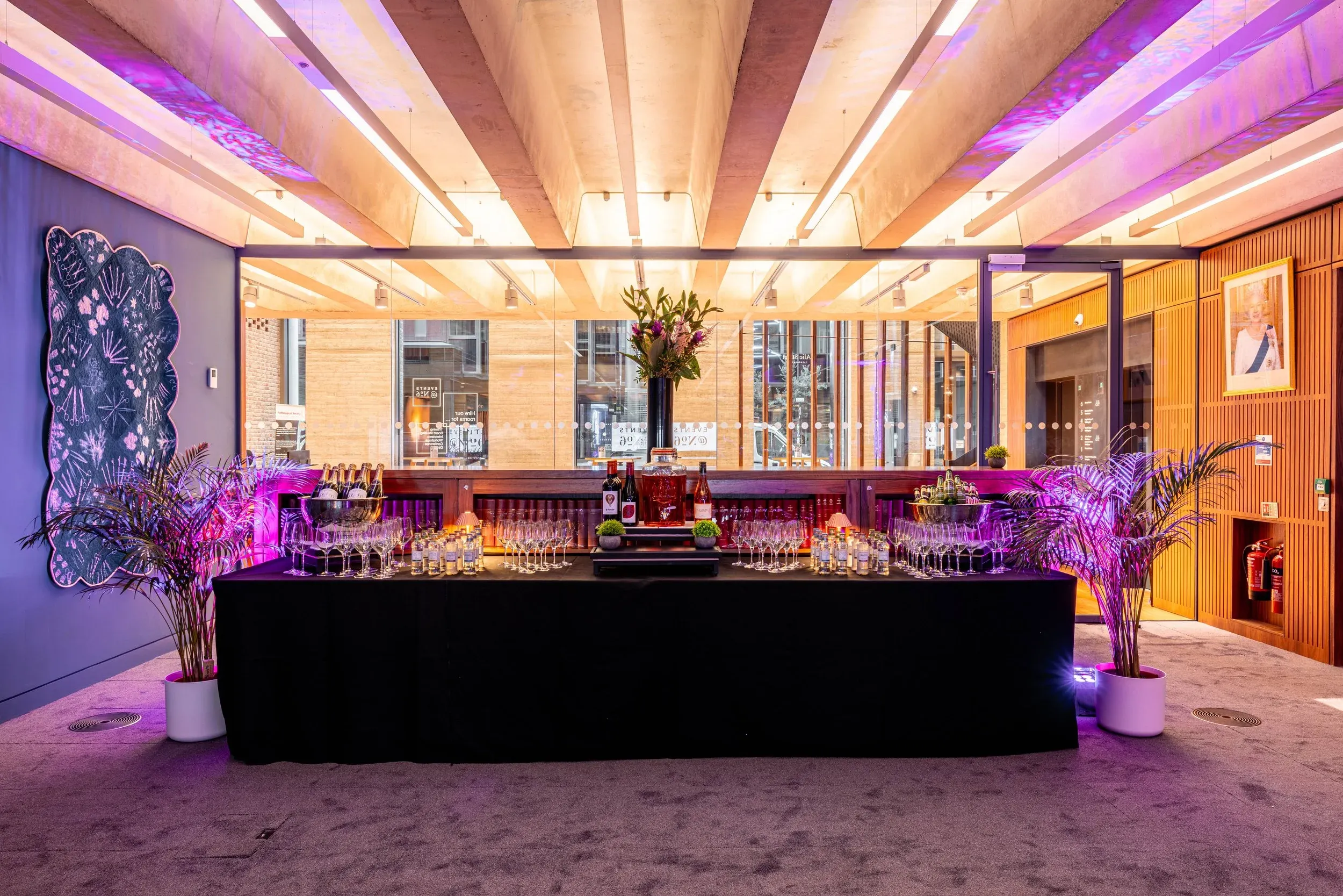 The bar at No6 set for a drinks reception, glassware laid out along a long table under coloured light.